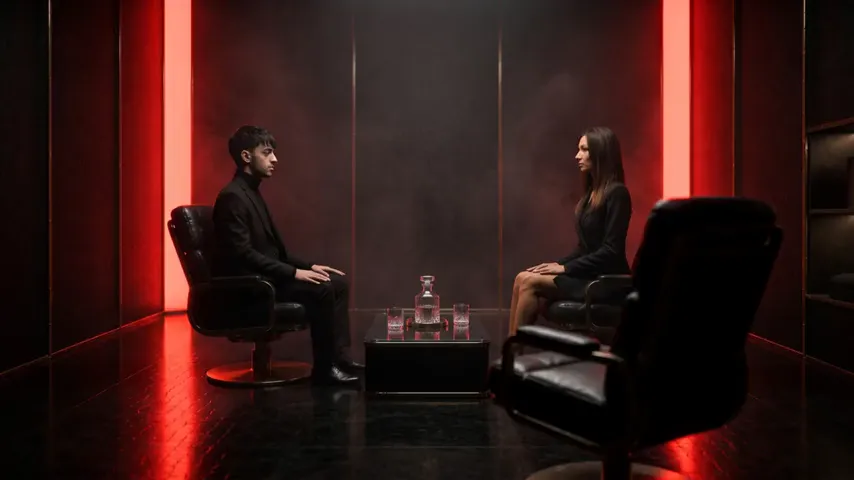 Rustam and Marija across the consultation table, an empty chair waiting on the near side.